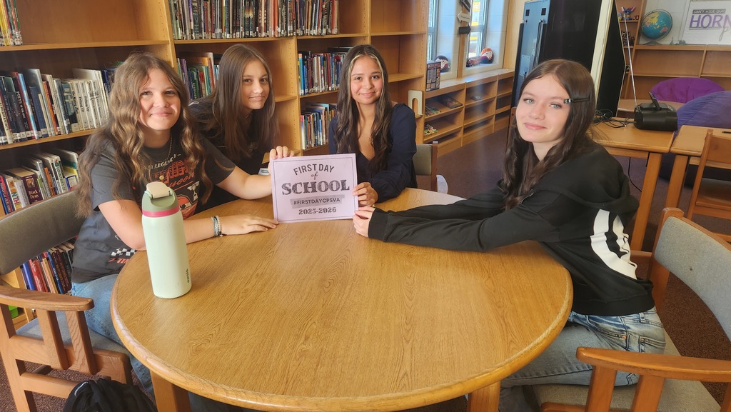 Four girls ready for the first day of school holding up a sign that says first day of school