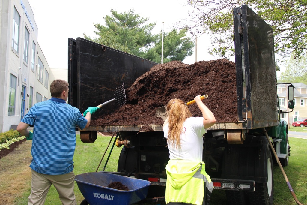 People unloading mulch from a truck