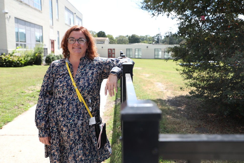 Principal in front of her school by the fence