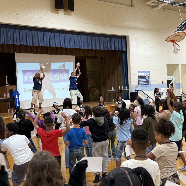 admin paper dance on stage with students standing up