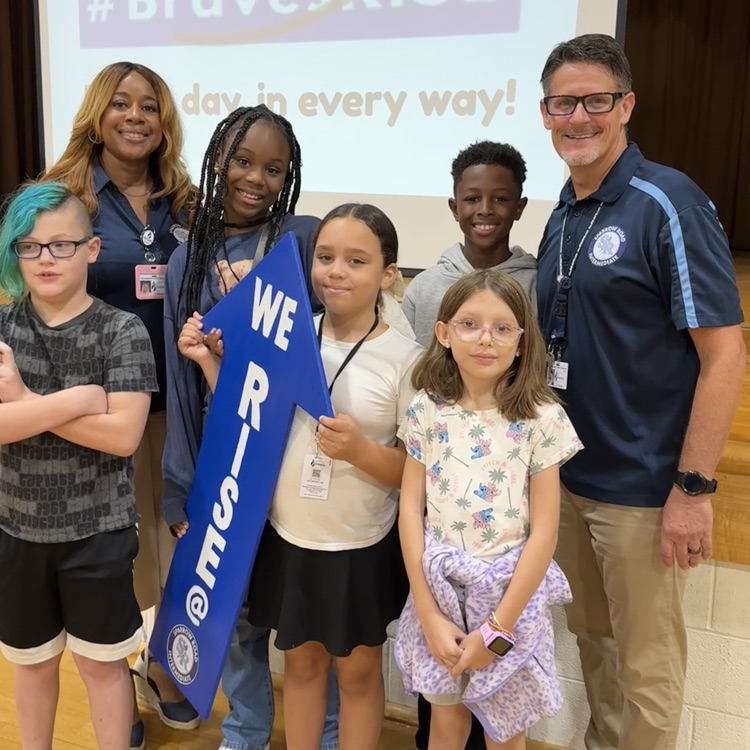 admin with students and we RISE arrow sign 