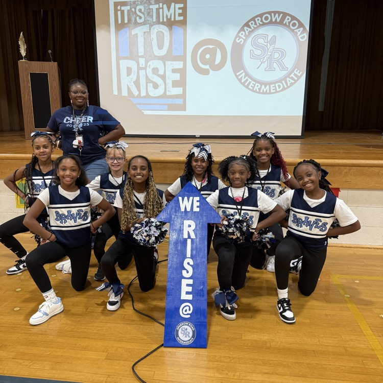 cheerleaders with we RISE arrow sign 