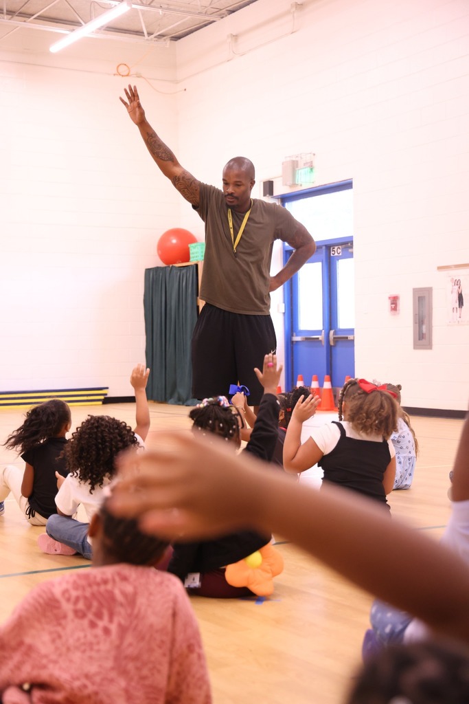 PE teacer with hand raised