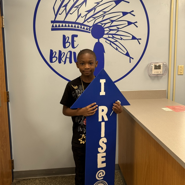 Travis with I RISE sign