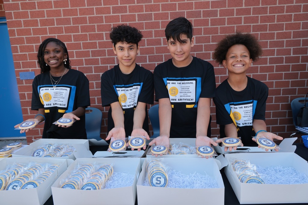 4 smithtech students holding cookies and smiling