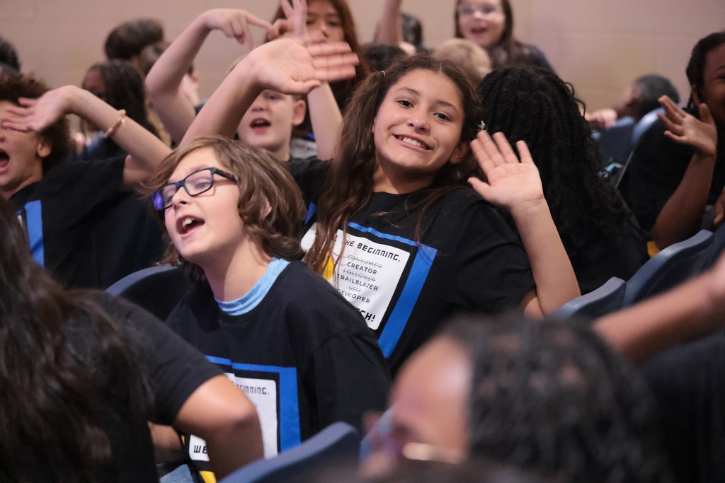 student waving with both hands