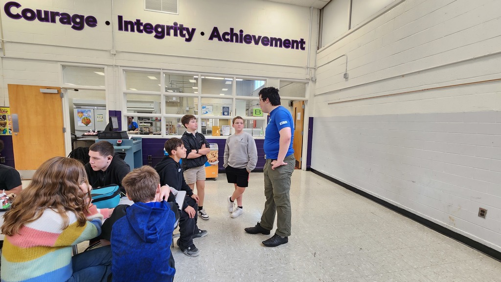 Scout Leader talking to  three students in cafeteria