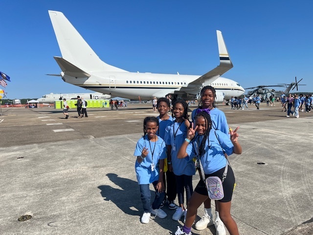 students with plane in background