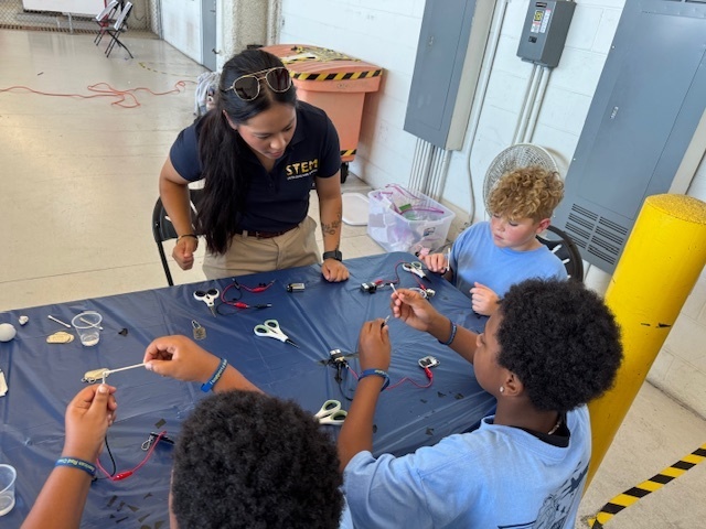 students working at a table with alligator clips