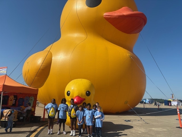 students with two large blow up ducks