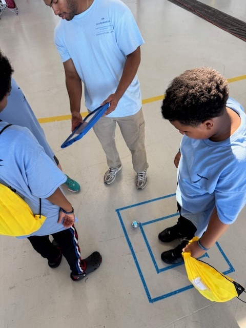 student standing  by a small robot