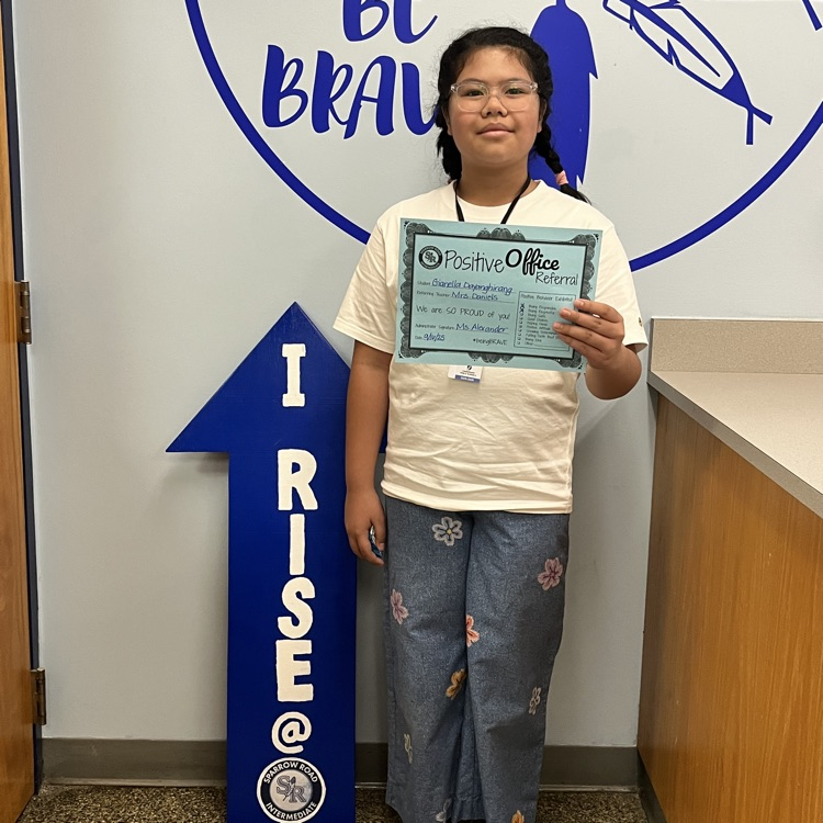 student holding Positive Office Referral