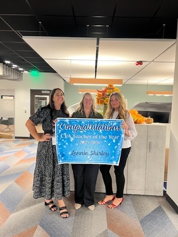 three women holding teacher of the year sign 