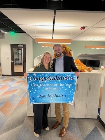Couple holding teacher of the year sign 