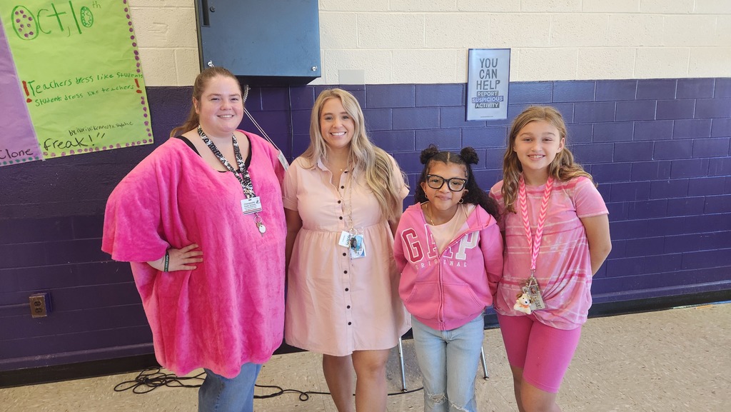 Two teachers and two students in pink or Spirit Day