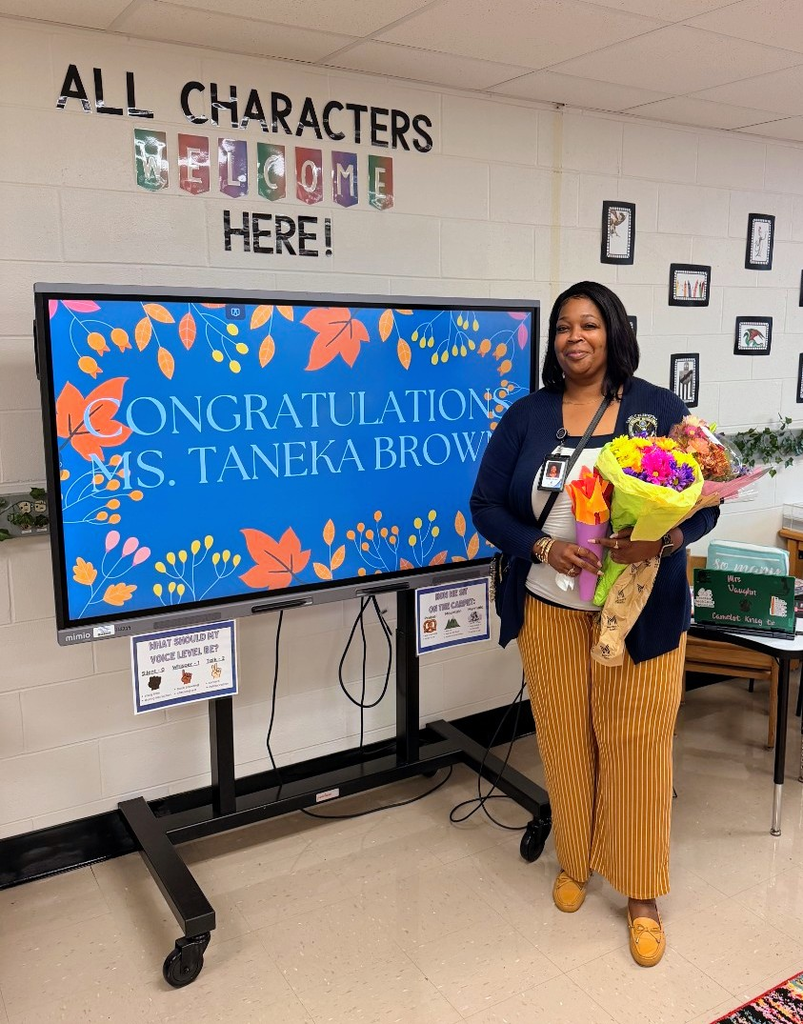 teacher of the year standing with flowers