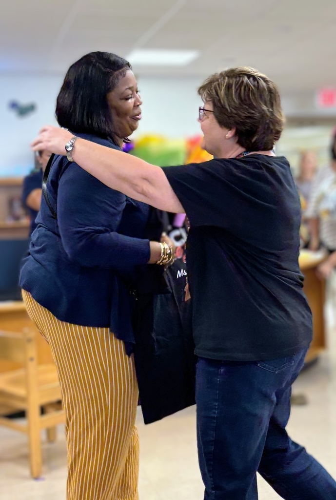 last year's teacher of the year hugging this year's teacher of the year