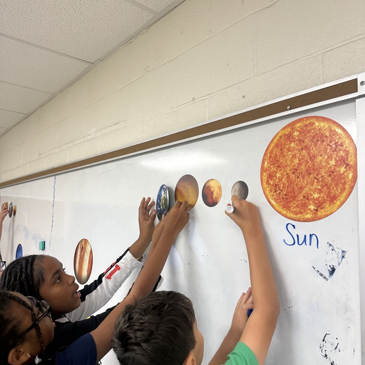students labeling planets on the board.