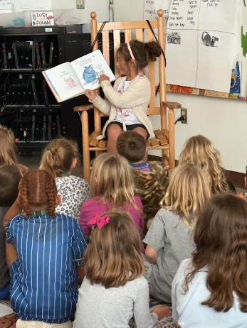 student reading to first graders