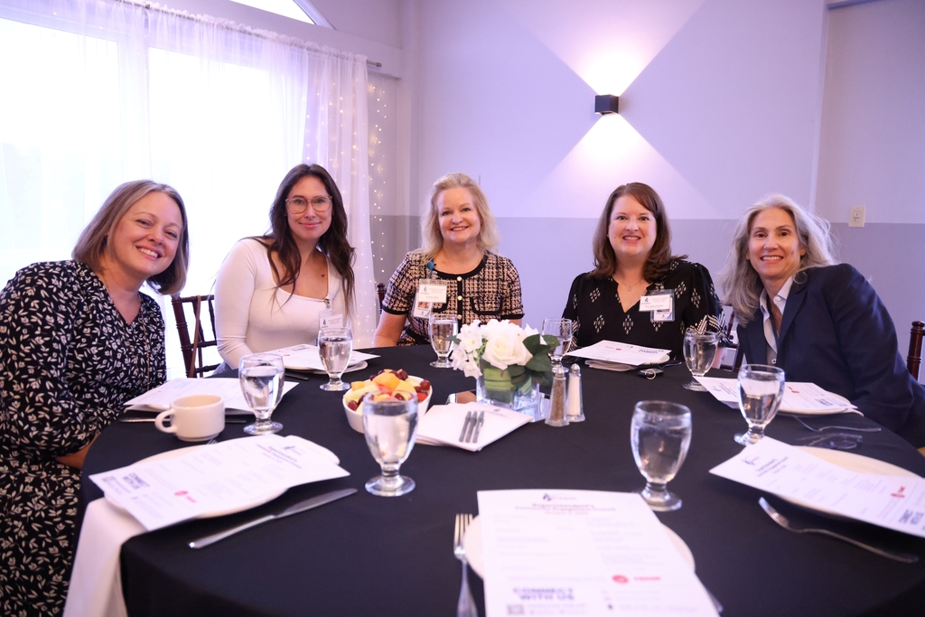 Principals and school leaders smiling at a table.