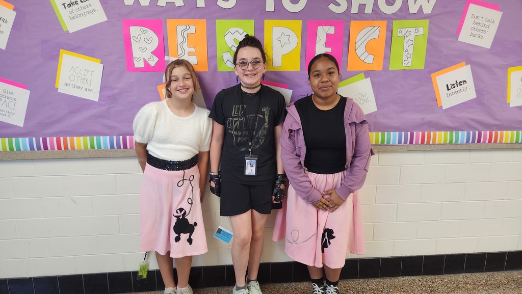Two girls in sock hop outfits and a girl in 80s rock outfit