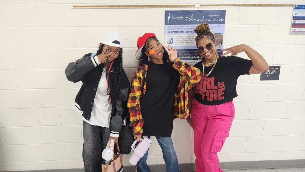 A teacher and two students dressed in 90s gear