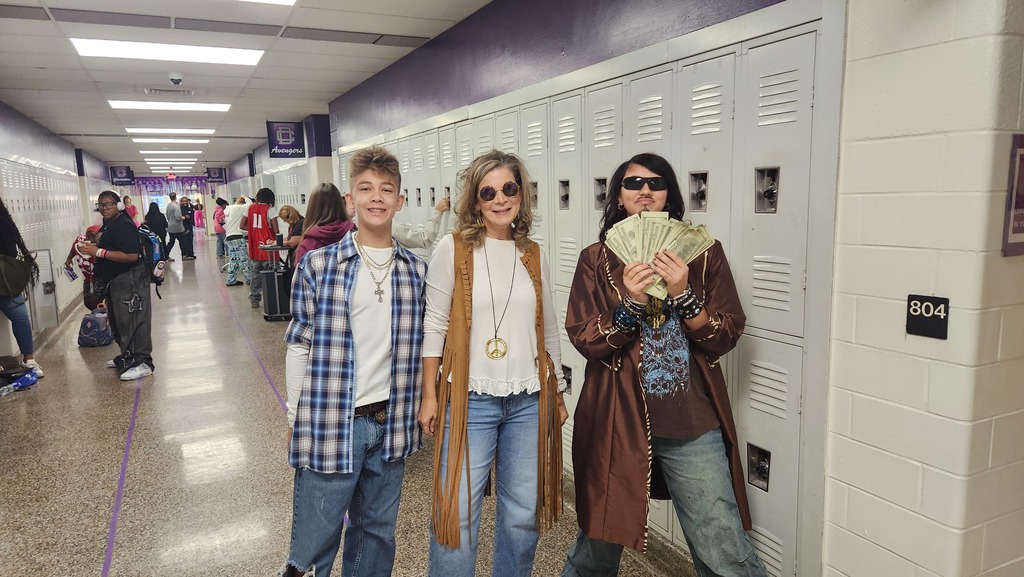 A teacher dressed as a hippie and two 90s kids