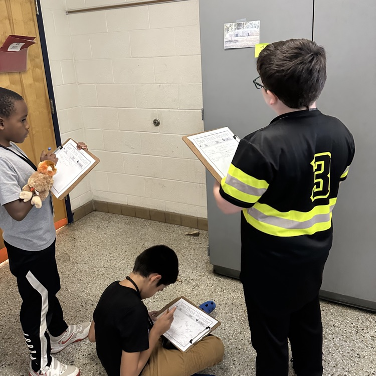students looking at picture and recording answers on paper