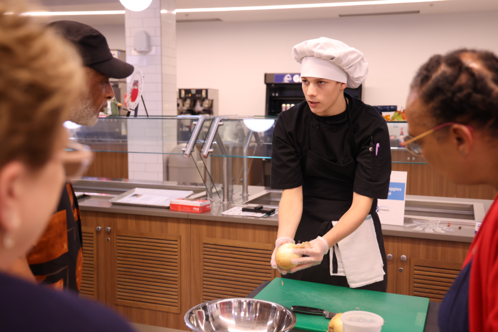male student helping adult prep food