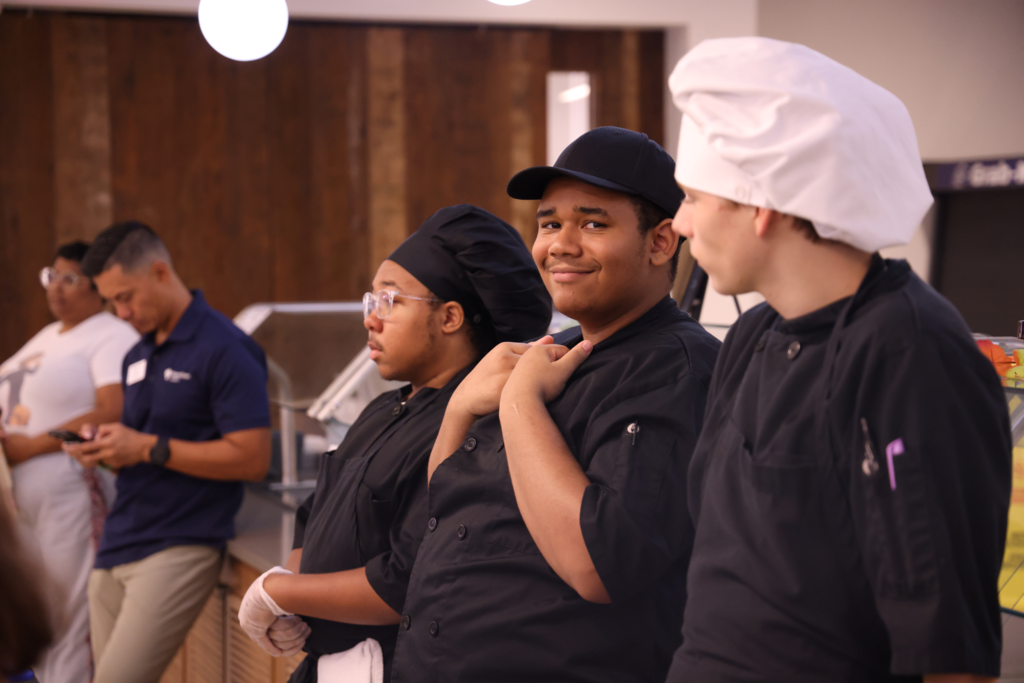 3 chefs one smiling for camera