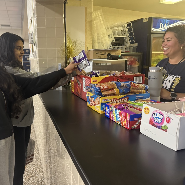 Administrator smiling celebrating a student.