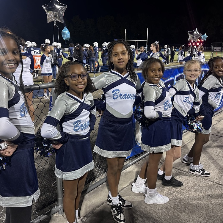 cheerleaders in front of fence