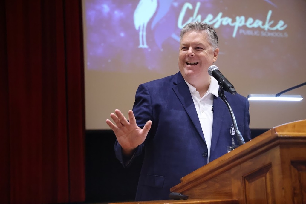 Dr. Cotton smiling at a podium