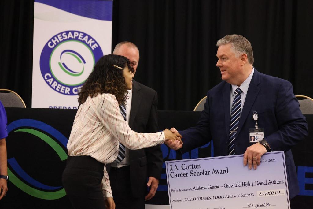 Dr. Cotton shaking hands with a scholarship winner