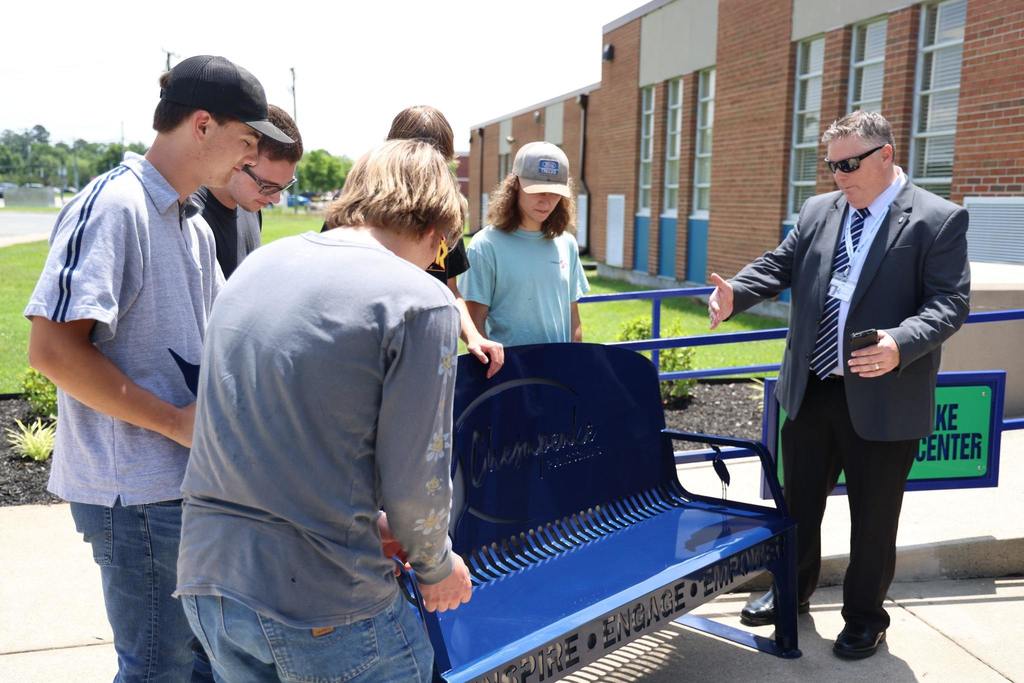 Dr. Cotton watching Career Center students install a bench