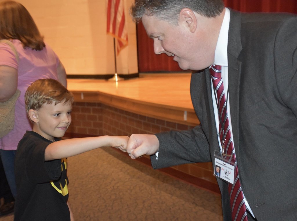 Dr. Cotton fist bumps a student