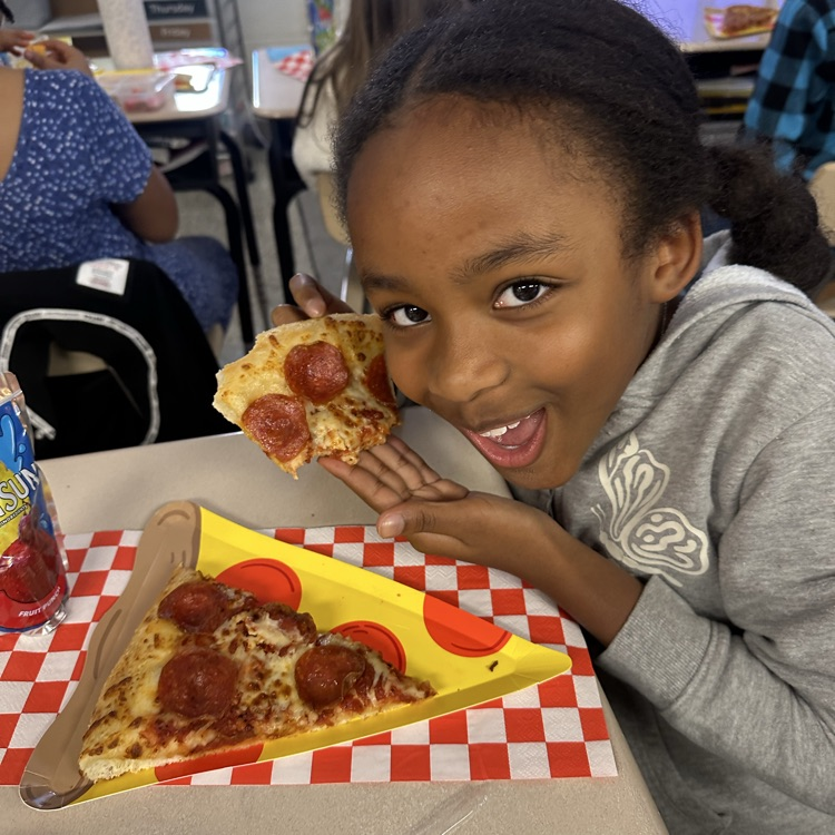 student with slice of pizza and pizza plate