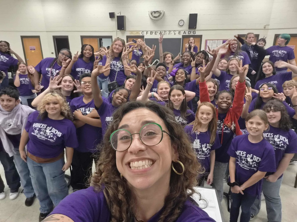 Students with Mrs. Mercier all wearing purple for a field trip!