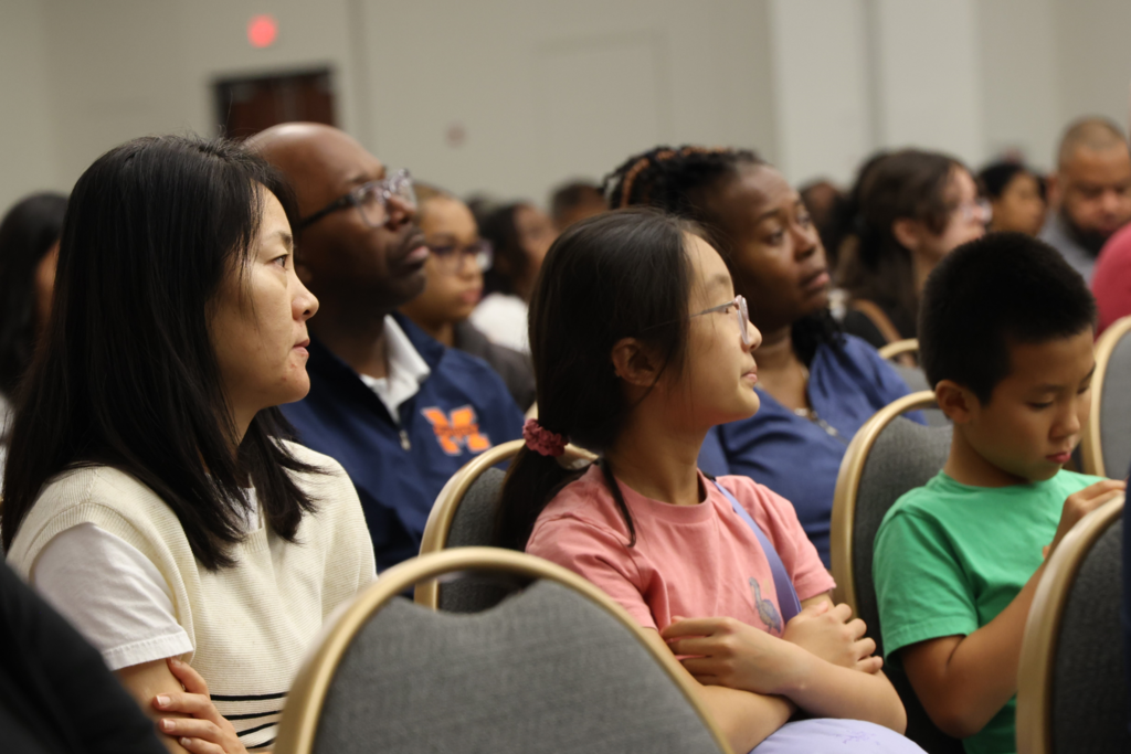 student and parent in big crow listening to presenter