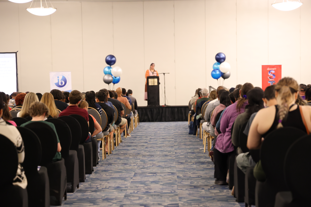 teacher speaking at podium and conference center