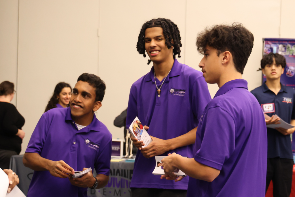 3 male SMA students smiling at guests