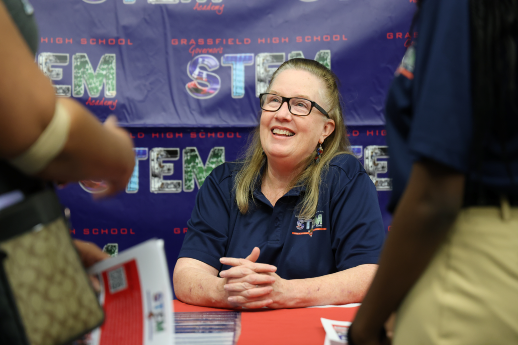 STEM teacher smiling at guests