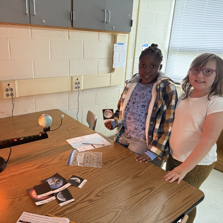 students with model of a full moon 