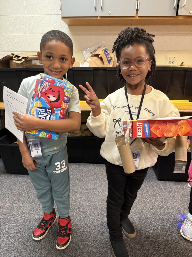 students holding their sun-blocking structures