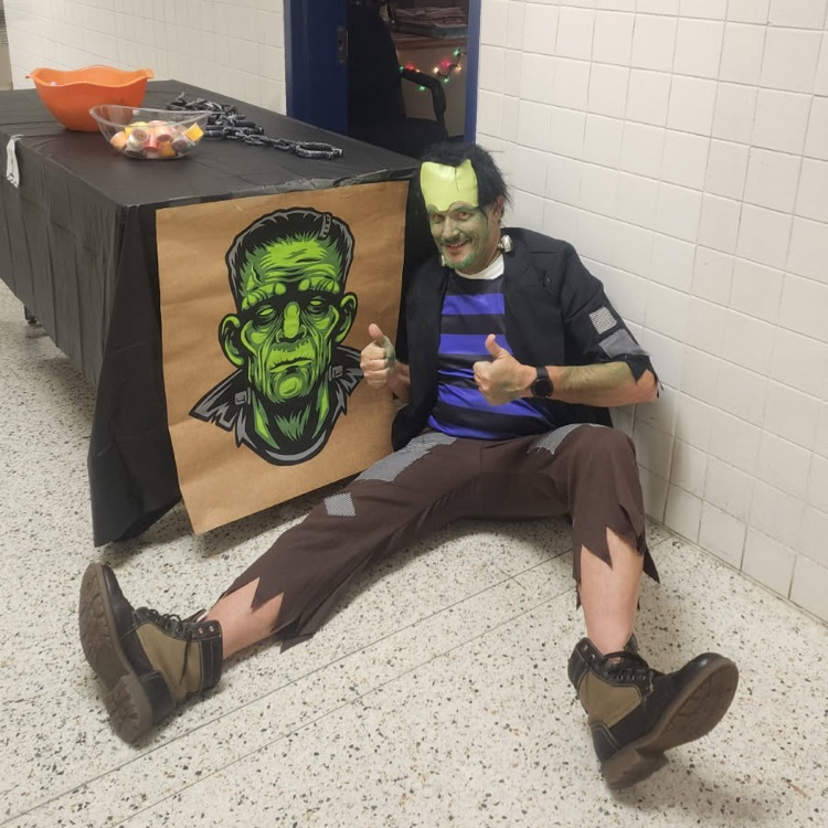 Mr. Triolet dressed as Frankenstein with a Frankenstein painting 