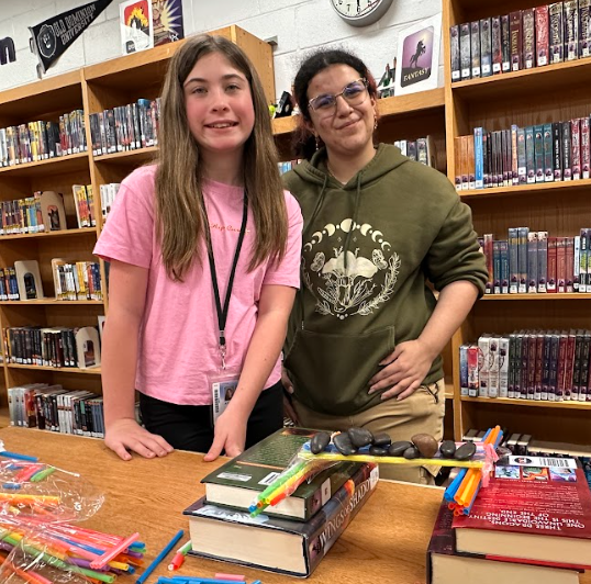 Two girls posing in front of their science experiment. 