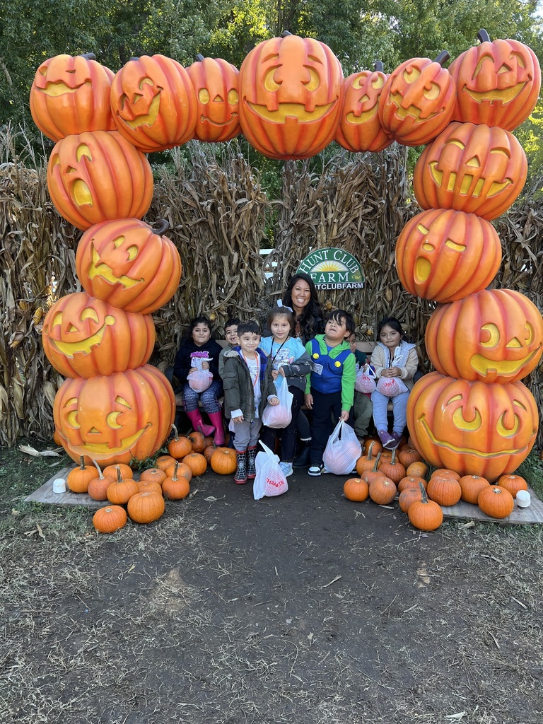 Kindergartners posing with the jack-o-lanterns