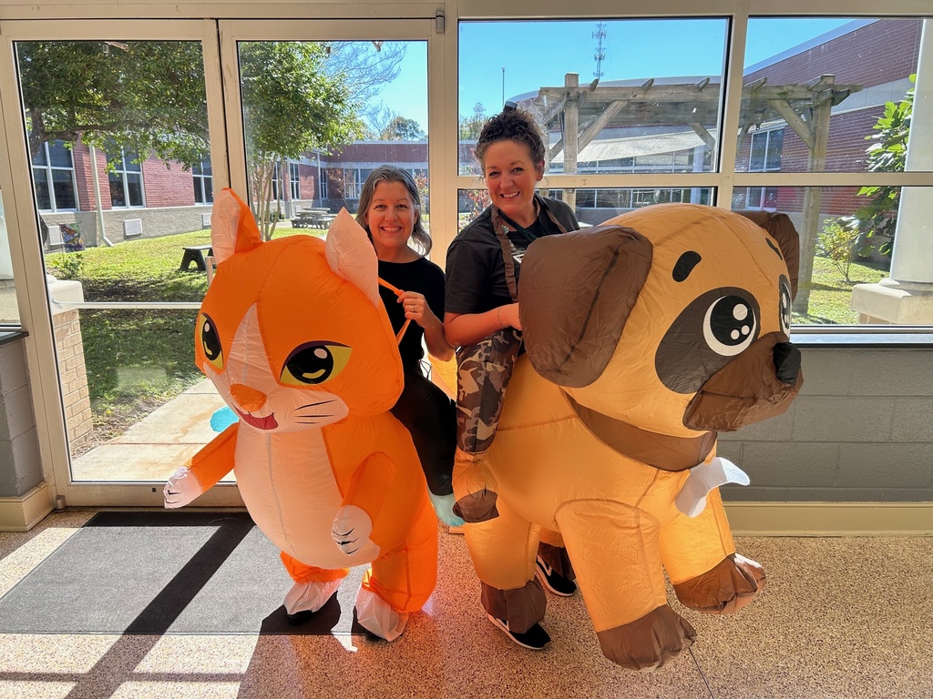 Principals wearing inflatable cat and dog costumes 