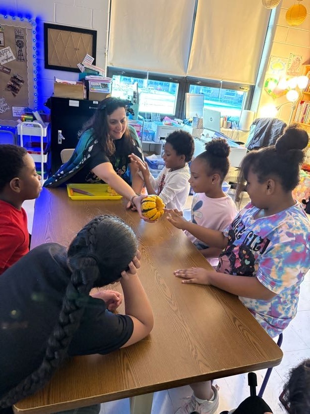 Mrs. Yohe lets student feel inside the pumpkin
