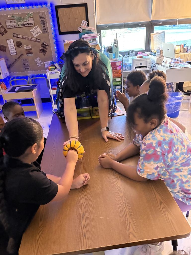 Mrs. Yohe lets student feel inside the pumpkin